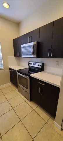 a kitchen with stainless steel appliances a stove a sink and a refrigerator