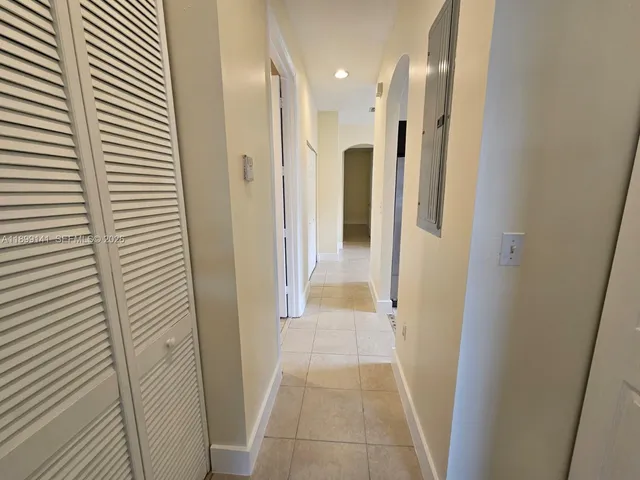 an empty room with windows and chandelier fan