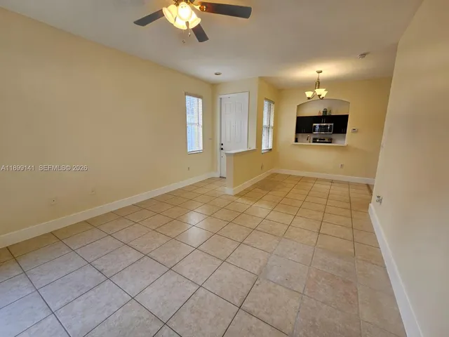 a view of an empty room with a chandelier fan