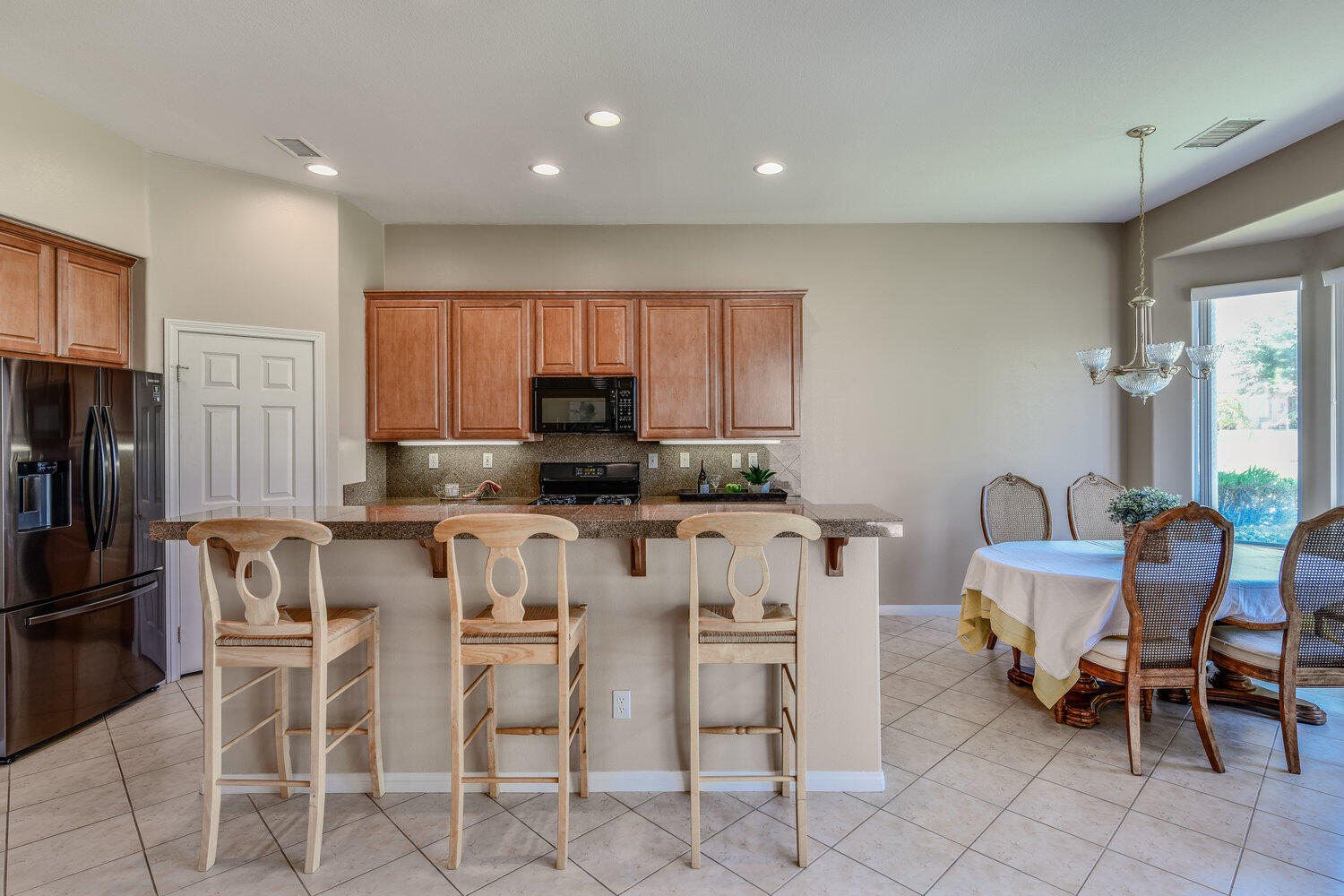 80538 Knightswood Road Indio, CA 92201 - Photo 11 of 32 a kitchen with stainless steel appliances kitchen island granite countertop a table and chairs in it