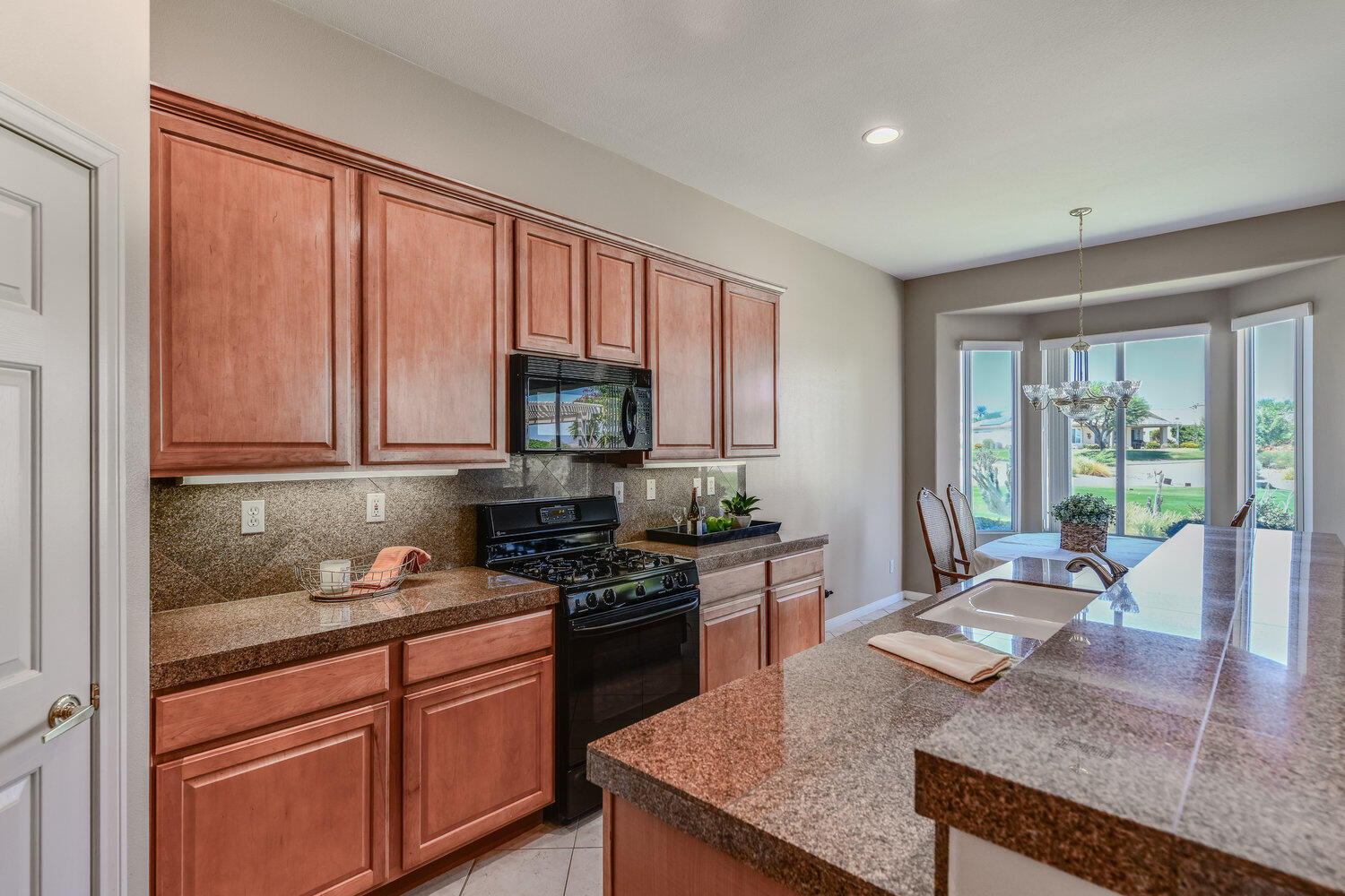 80538 Knightswood Road Indio, CA 92201 - Photo 12 of 32 a kitchen with granite countertop a stove a sink and a cabinets
