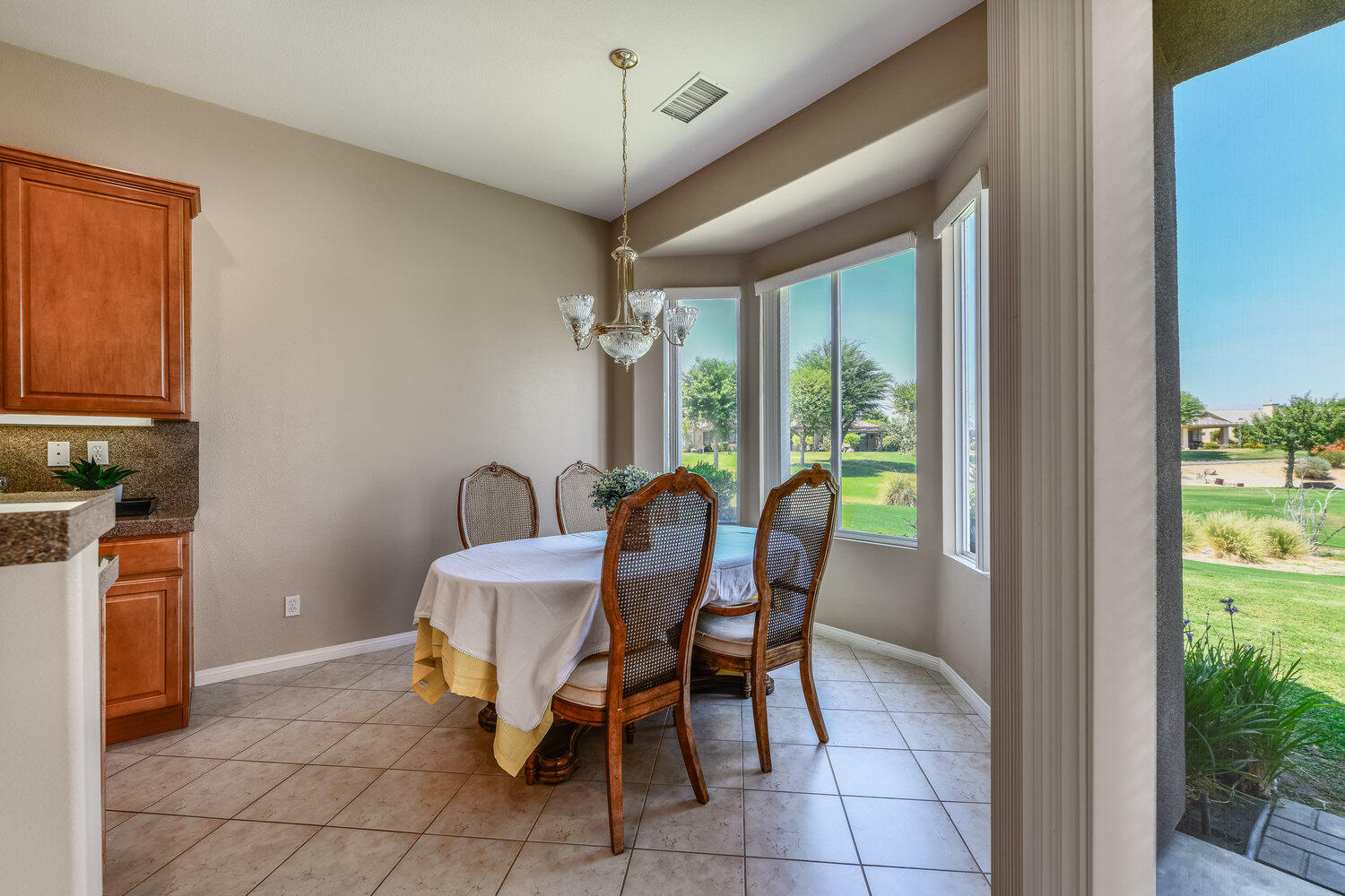 80538 Knightswood Road Indio, CA 92201 - Photo 15 of 32 a dining room with furniture and a floor to ceiling window