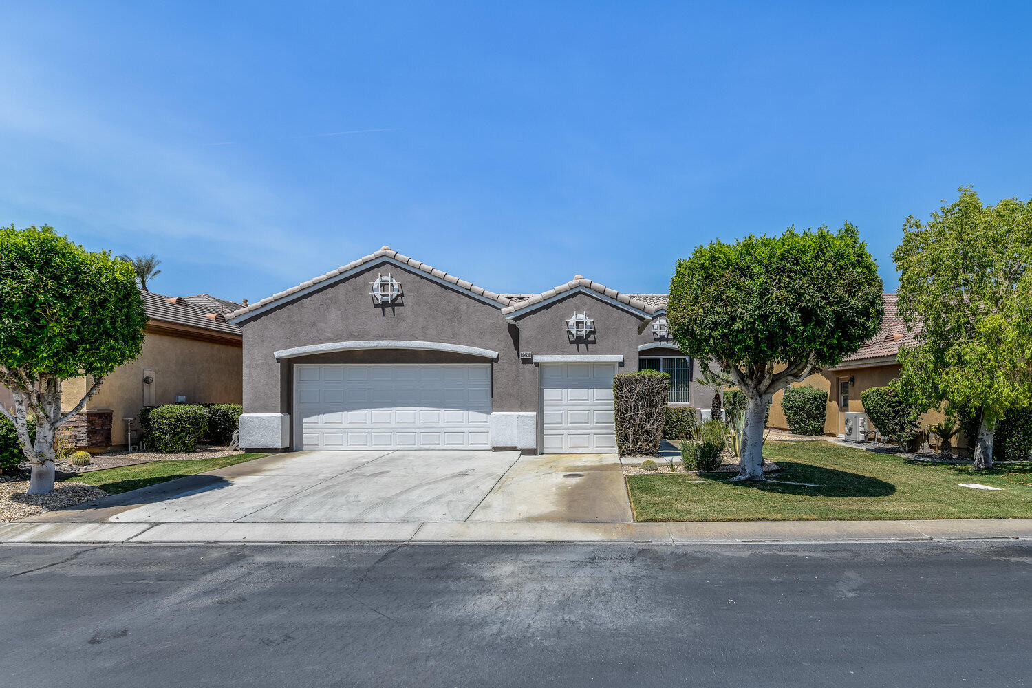 80538 Knightswood Road Indio, CA 92201 - Photo 3 of 32 a front view of a house with a yard and garage