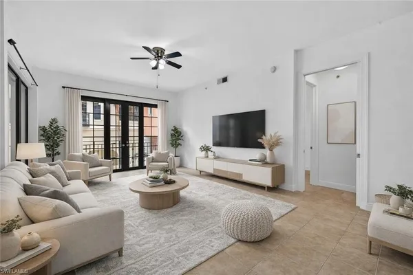 a living room with furniture a flat screen tv and a large window