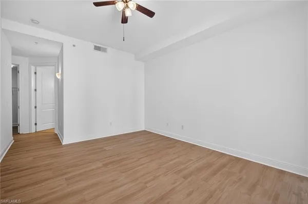 a view of an empty room with wooden floor