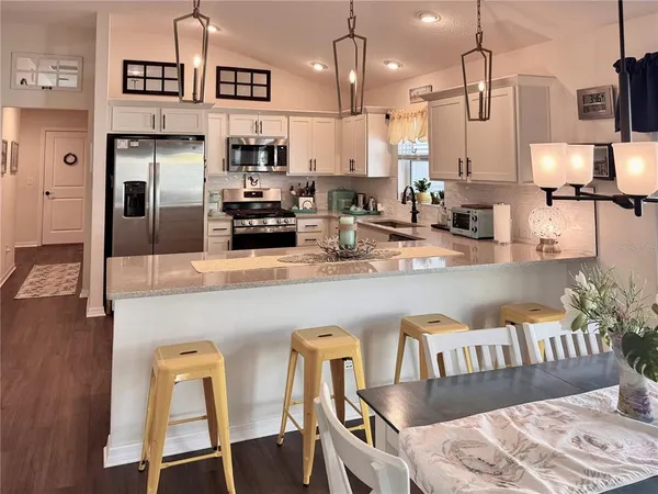 a kitchen with stainless steel appliances granite countertop a refrigerator a stove and a sink