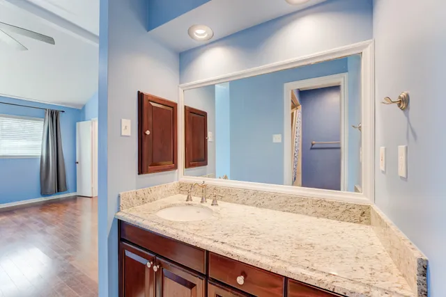 a bathroom with a granite countertop sink and a mirror