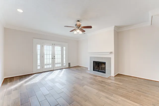wooden floor fireplace and windows in an empty room