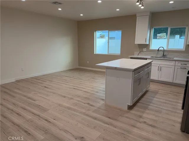 a kitchen with a sink cabinets and wooden floor