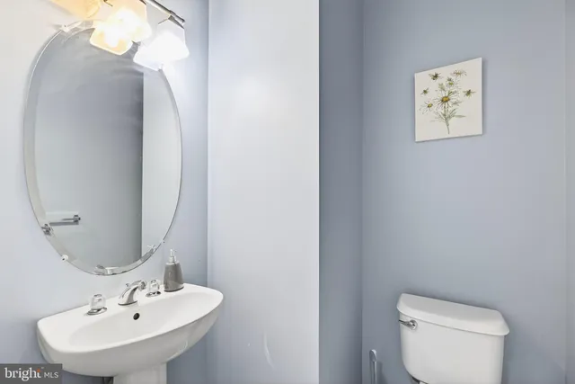a bathroom with a toilet a sink and mirror