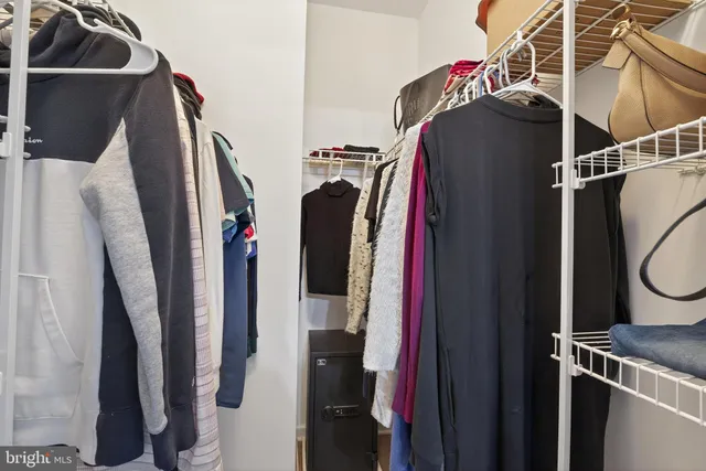 a view of walk in closet with clothes and shoes