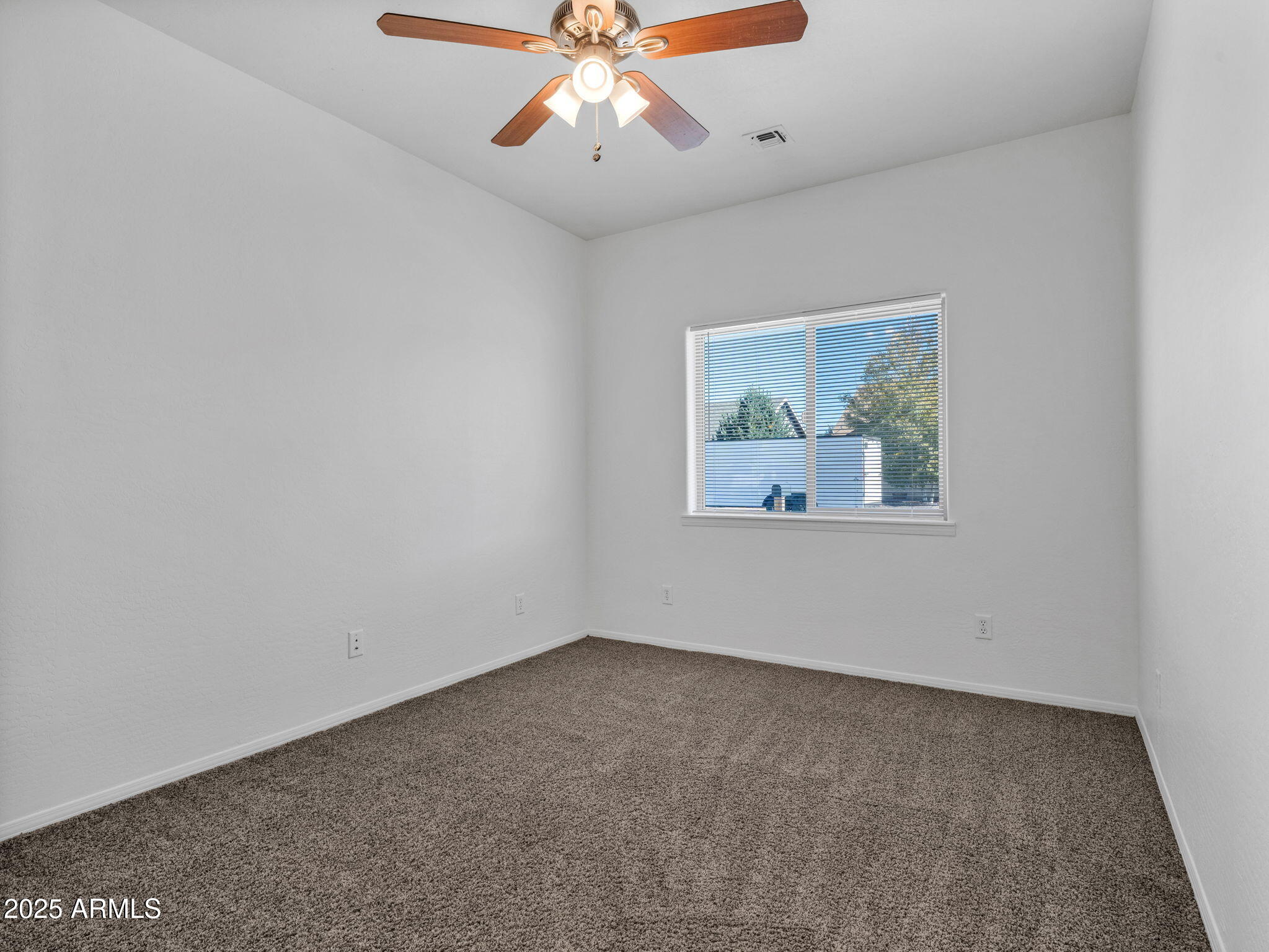 907 Quarter Horse Road Williams, AZ 86046 - Photo 12 of 26 an empty room with a window and a ceiling fan