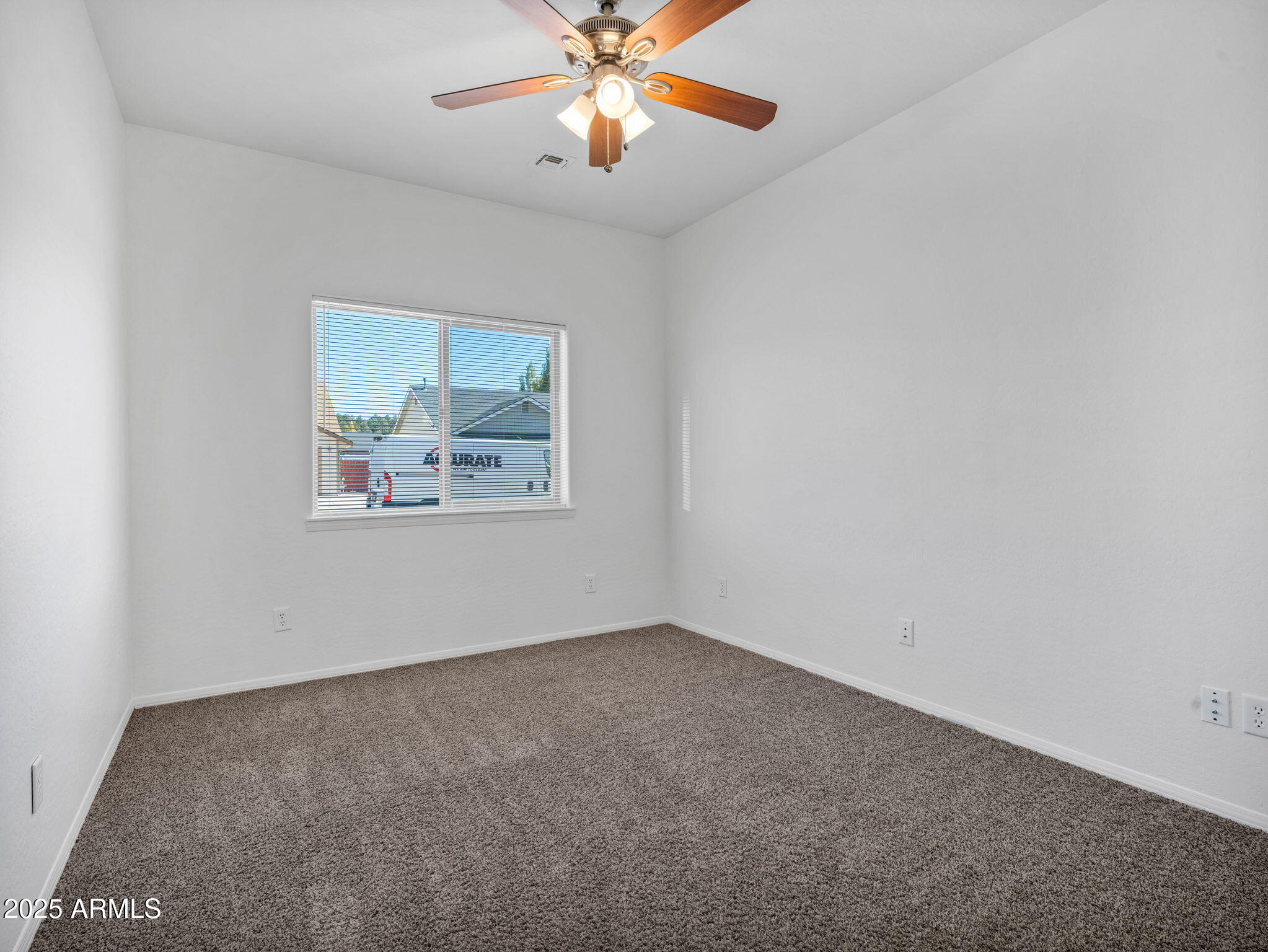 907 Quarter Horse Road Williams, AZ 86046 - Photo 14 of 26 an empty room with chandelier fan and window