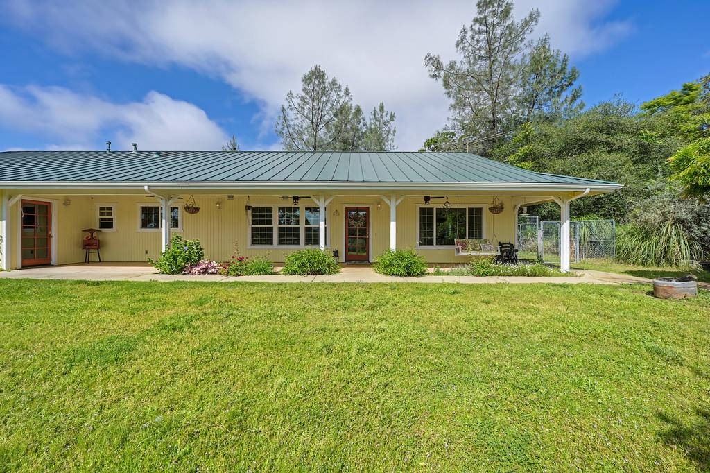 6181 Lambert Lane El Dorado, CA 95623 - Photo 5 of 68 view of front of home featuring an attached carport, a standing seam roof, and covered porch. dog run/fenced area to the right of the house