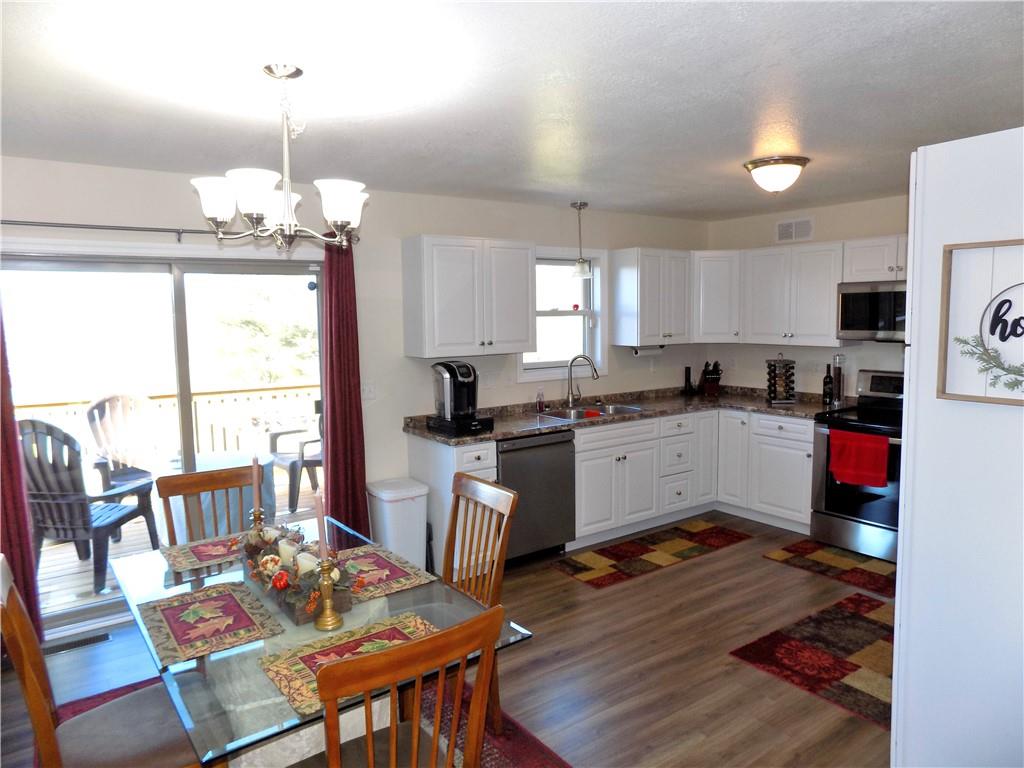 175 Springer Road McClellandtown, PA 15458 - Photo 5 of 18 a kitchen with a refrigerator a stove a sink dishwasher a dining table and chairs with wooden floor
