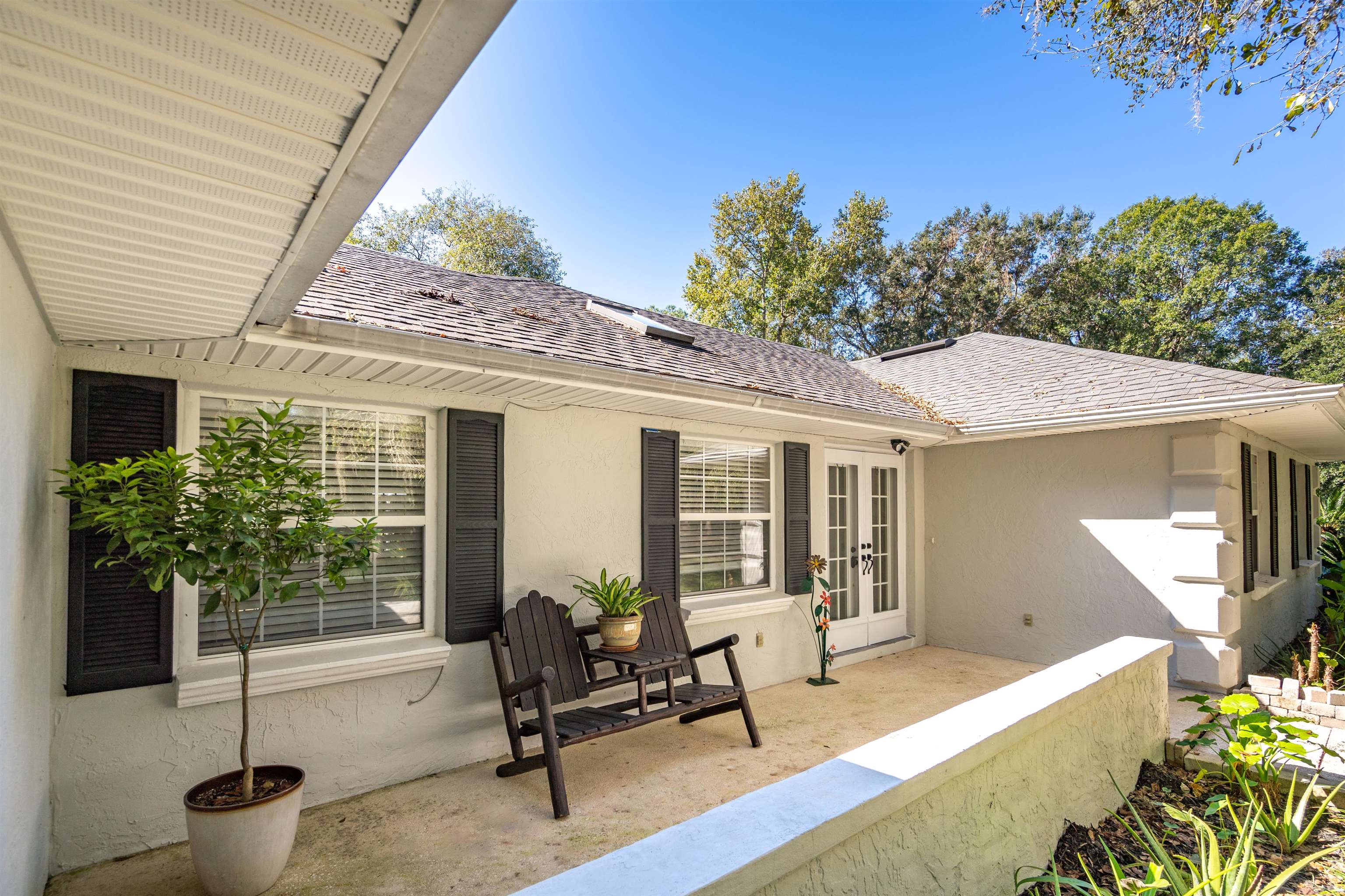 5525 St Ambrose Church Road Elkton, FL 32033 - Photo 3 of 66 a view of a patio with table and chairs potted plants and floor to ceiling window