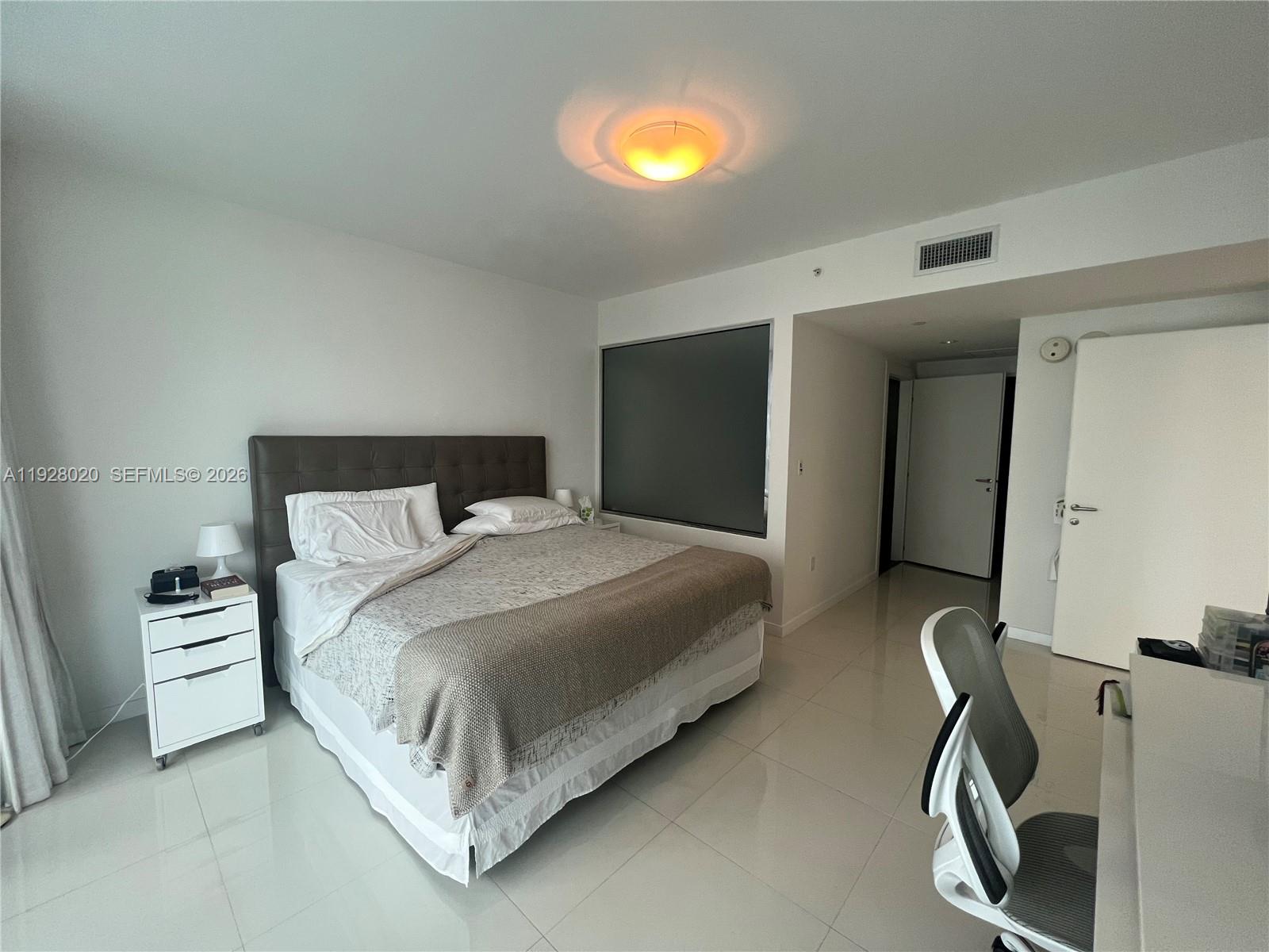 200 Biscayne Blvd Way, Unit 3106 Miami, FL 33131 - Photo 14 of 27 a bedroom with a bed and with a mirror