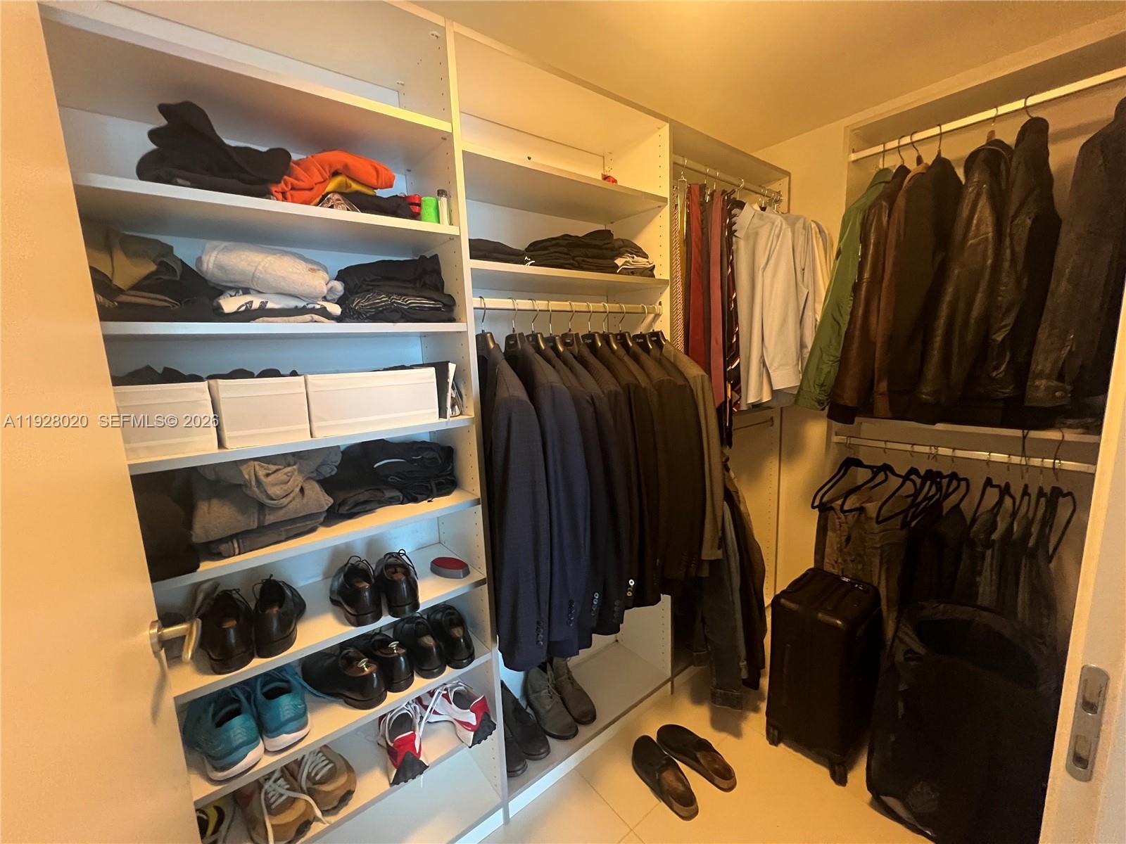 200 Biscayne Blvd Way, Unit 3106 Miami, FL 33131 - Photo 16 of 27 a view of walk in closet with clothes and shoes
