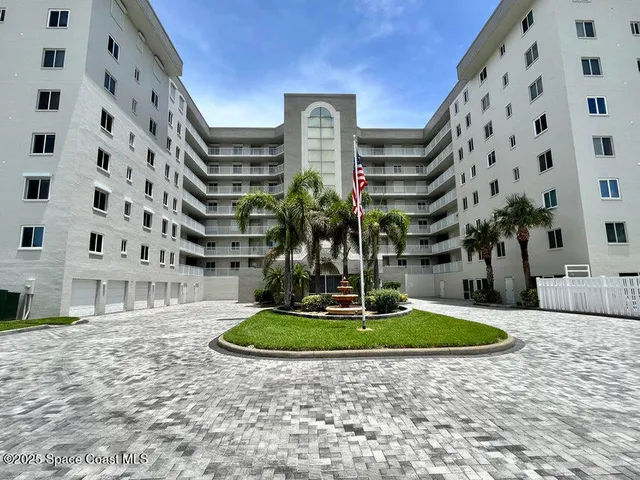 a view of tall building with a fountain in front of it