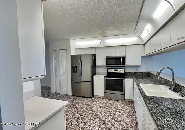 a kitchen with a refrigerator sink and wooden floor