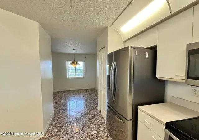 a kitchen with stainless steel appliances granite countertop a refrigerator and a stove