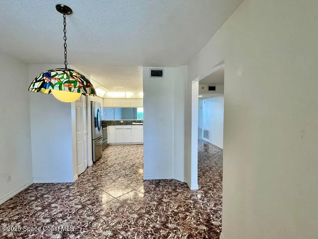 a view of a hallway to a livingroom with a chandelier