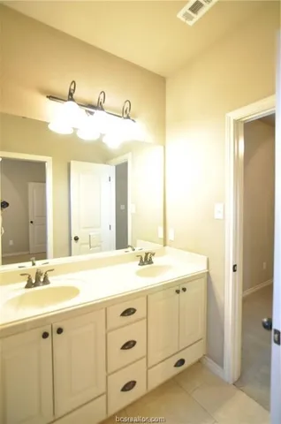 a bathroom with a double vanity sink and a mirror