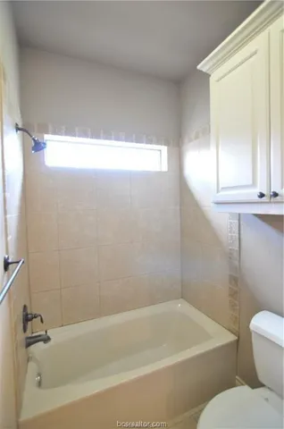 a white bath tub sitting next to a white toilet