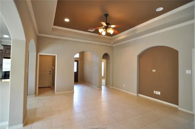 an empty room with chandelier and entrance