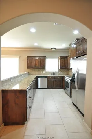 a large kitchen with a large counter top and stainless steel appliances