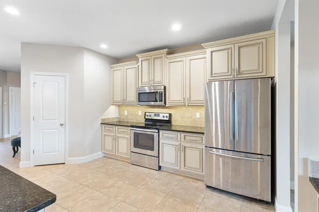 a large kitchen with granite countertop a sink and a stove