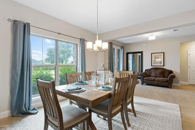 a dining room with furniture a chandelier and wooden floor