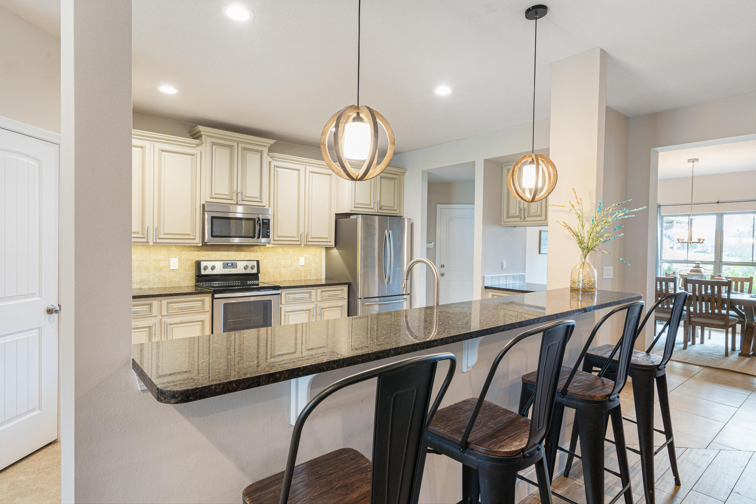 4646 Chanan Drive Crestview, FL 32539 - Photo 8 of 56 a kitchen with stainless steel appliances granite countertop a stove a sink a dining table and chairs with wooden floor
