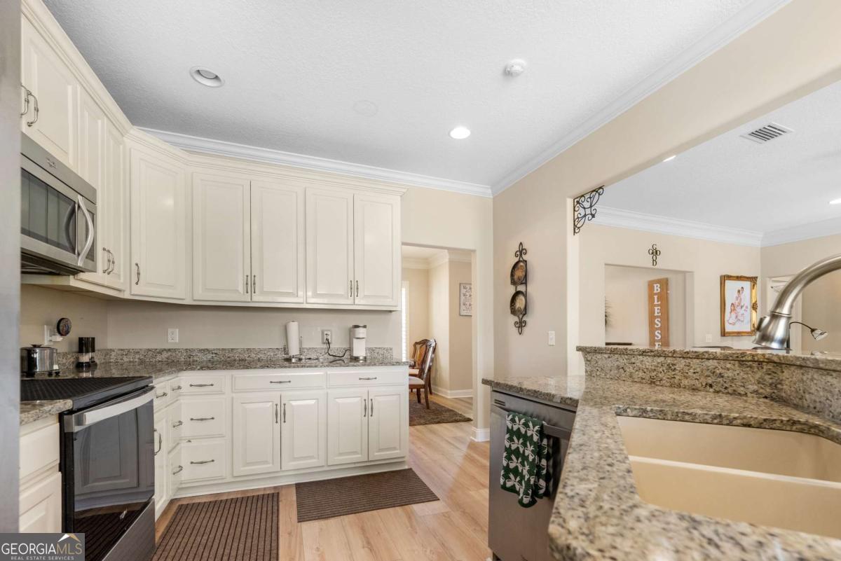 105 Plantation Pnes Drive Blackshear, GA 31516 - Photo 24 of 48 a kitchen with granite countertop white cabinets and white appliances