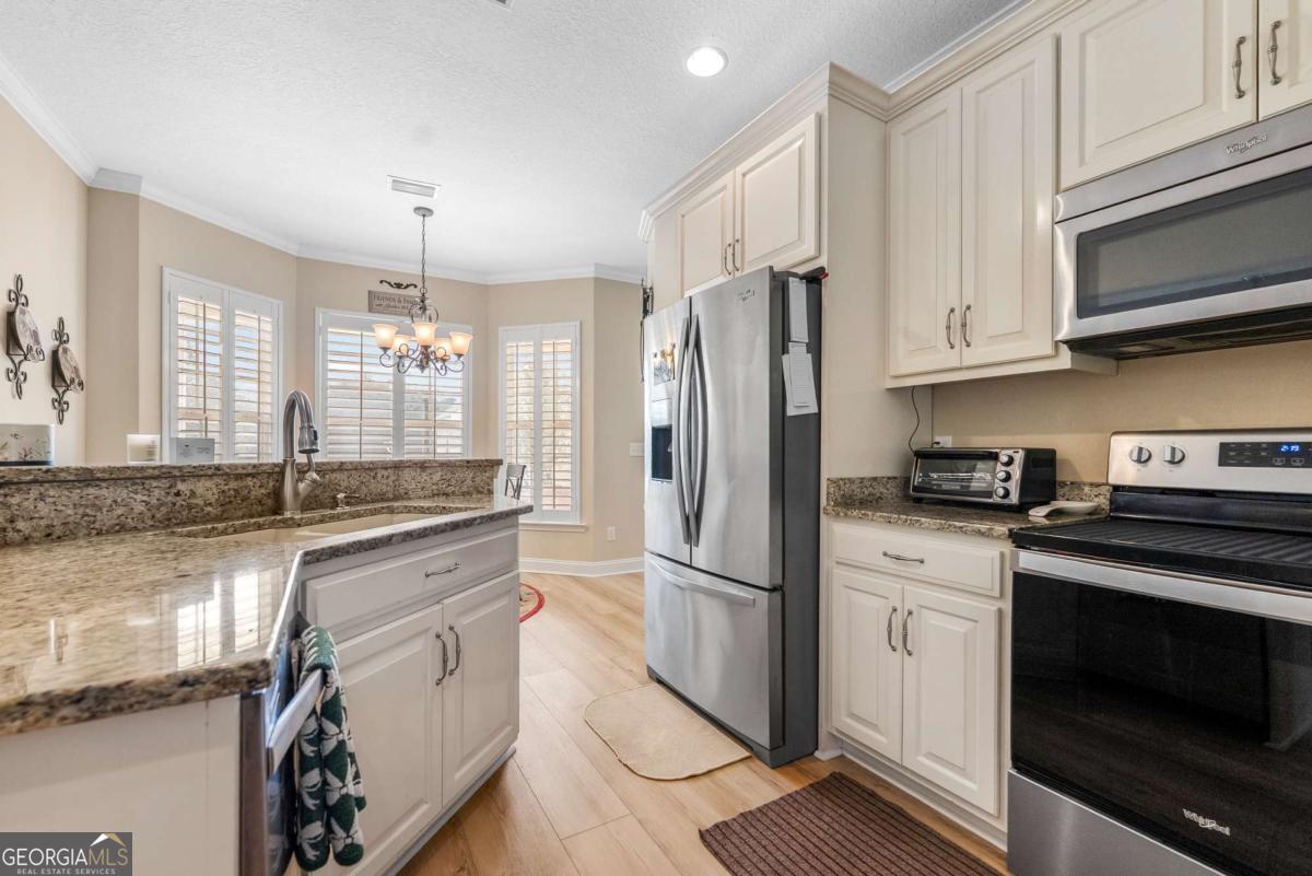 105 Plantation Pnes Drive Blackshear, GA 31516 - Photo 25 of 48 a kitchen with granite countertop a refrigerator stove and sink
