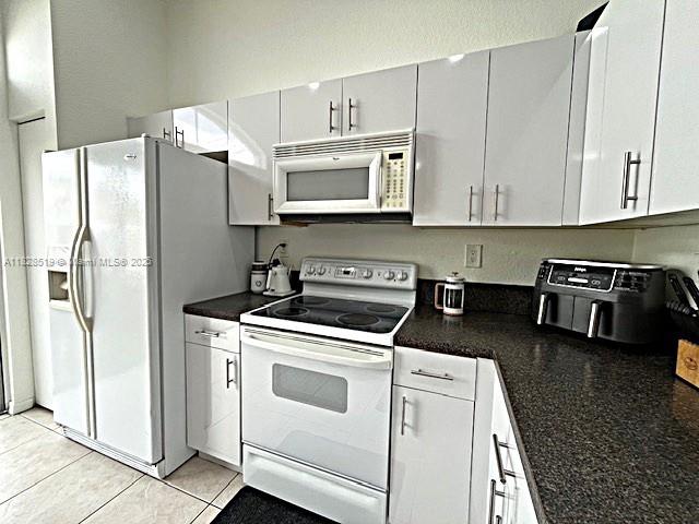 1988 Southeast 12th Street Homestead, FL 33035 - Photo 28 of 44 a kitchen with stainless steel appliances granite countertop a refrigerator stove and white cabinets