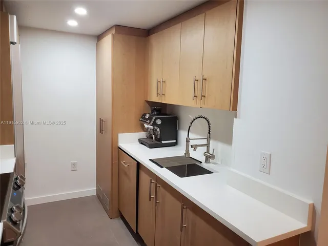 a view of a kitchen with sink and cabinets