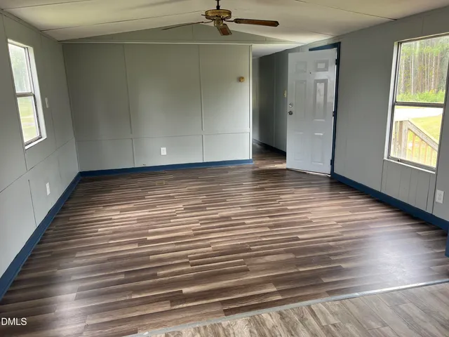 a view of a room with wooden floor and window