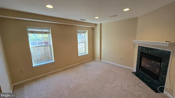 a view of an empty room with a fireplace and a window