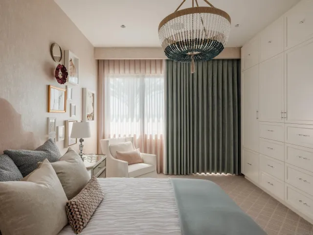 a living room with furniture a flat screen tv and floor to ceiling window