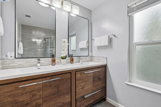 a bathroom with a double vanity sink and mirror