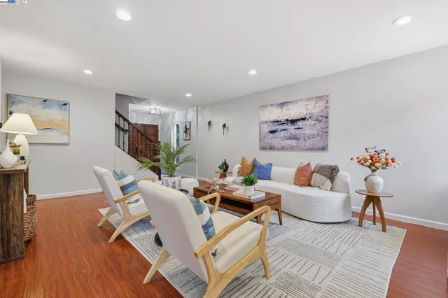 a living room with furniture and a wooden floor