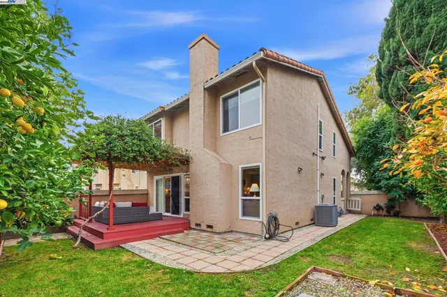 a view of a house with a yard potted plants and large tree