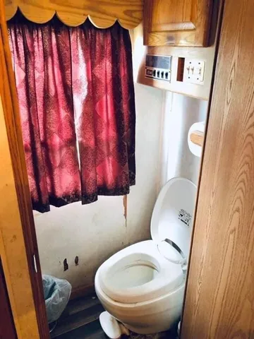 a bathroom with a toilet and a shower curtain