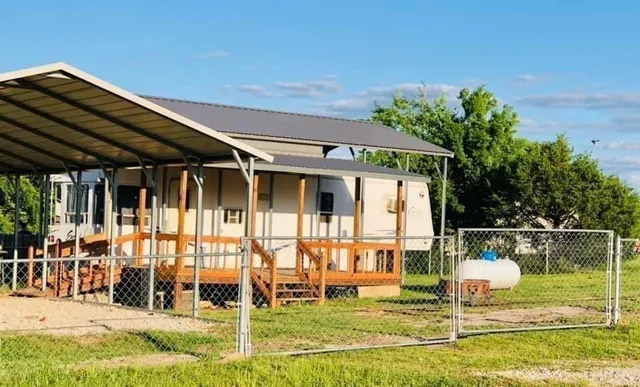 a backyard of a house with yard table and chairs