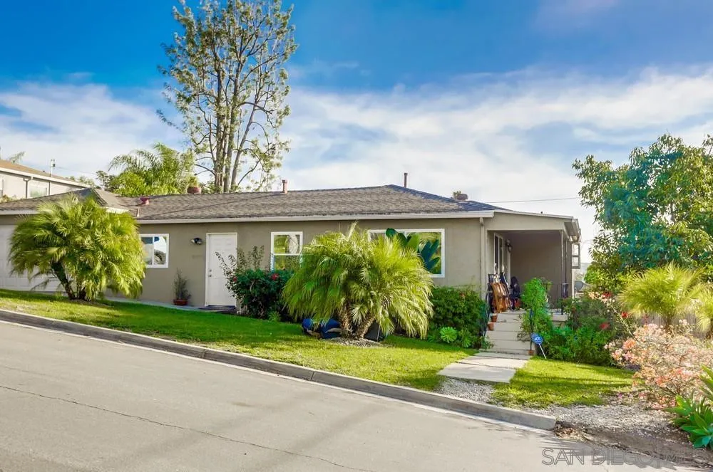 a front view of a house with a yard and potted plants