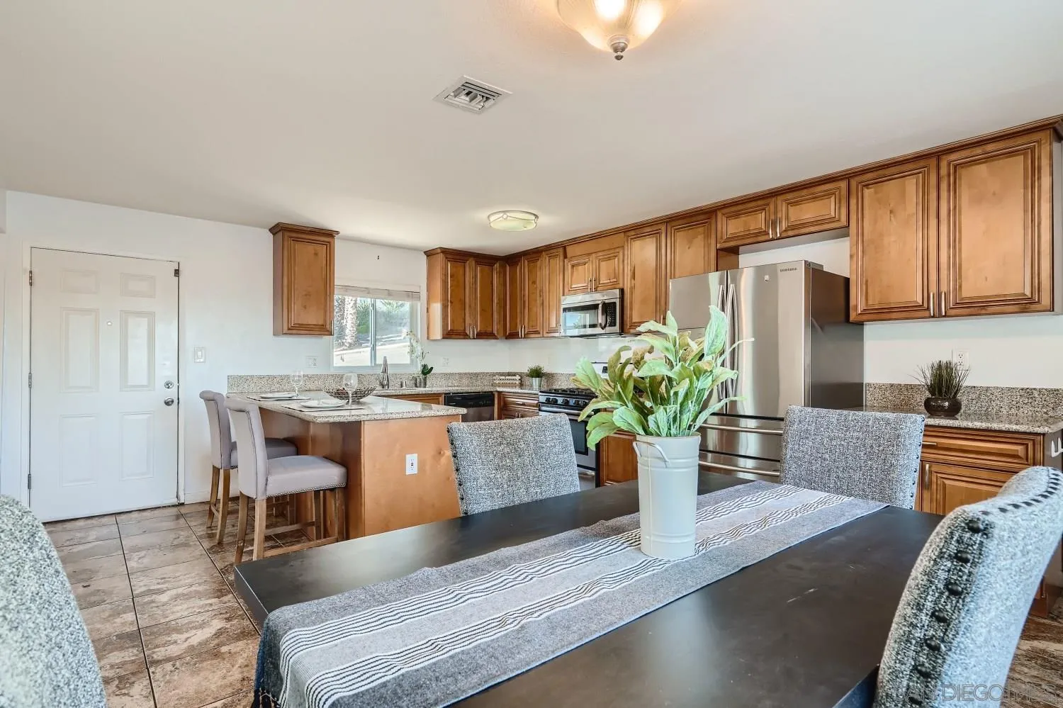 4817 Maple Avenue La Mesa, CA 91942 - Photo 13 of 31 a kitchen with a refrigerator and a table