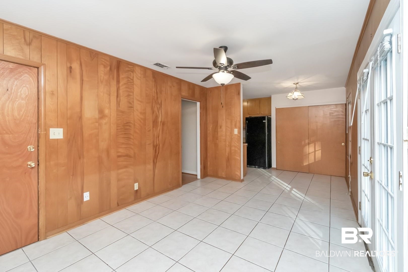 5517 Vanderbilt Drive Mobile, AL 36608 - Photo 12 of 33 Spare room featuring wood walls, ceiling fan, and light tile patterned flooring