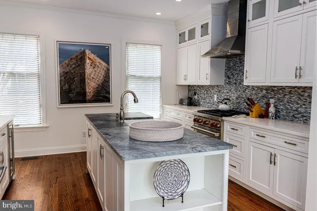 a kitchen with granite countertop a sink a stove and wooden floor