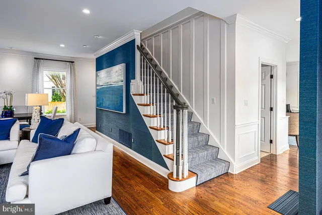 a living room with furniture and wooden floor next to a window